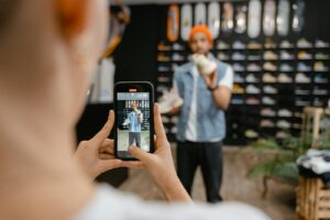 Une personne filme une expérience d'achat de chaussures dans un magasin branché à l'aide d'un smartphone.